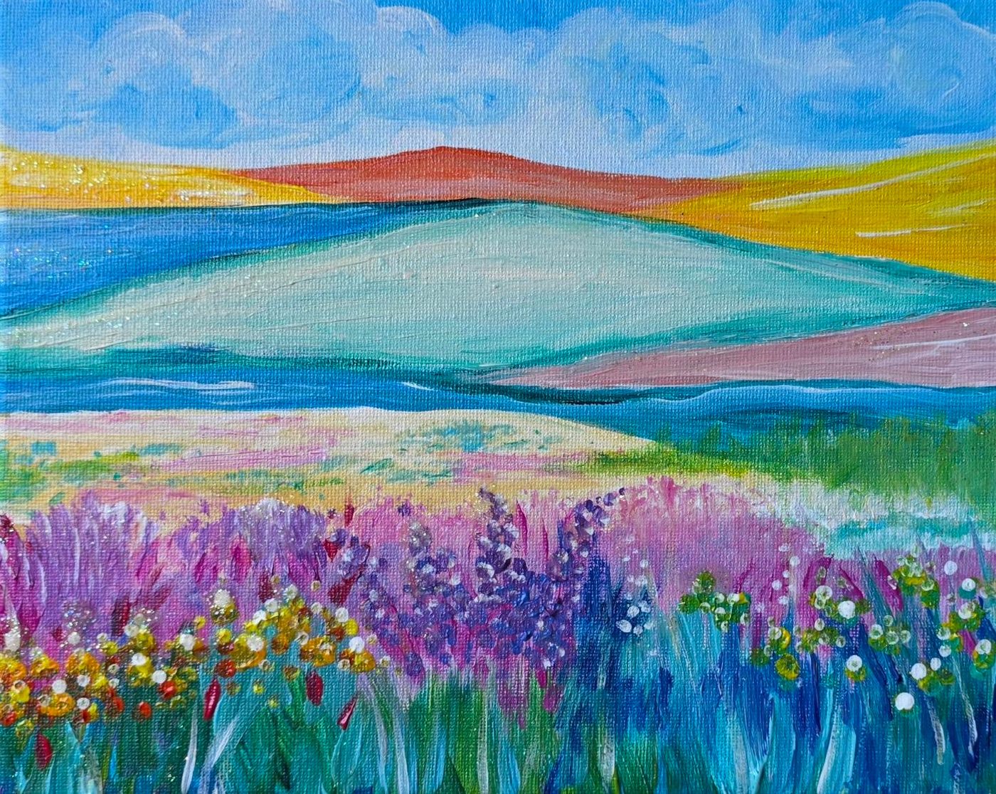 Acrylic landscape of rolling pastel hills with a foreground of pink, purple, and yellow wildflowers